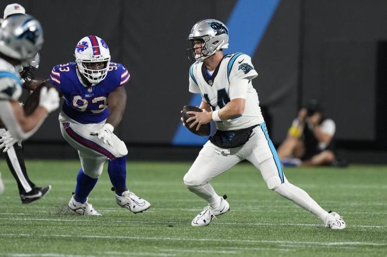 Aug 26, 2022; Charlotte, North Carolina, USA; Carolina Panthers quarterback Sam Darnold (14) is forced from the pocket by the Buffalo Bills defense during the second quarter at Bank of America Stadium. Mandatory Credit: Jim Dedmon-USA TODAY Sports