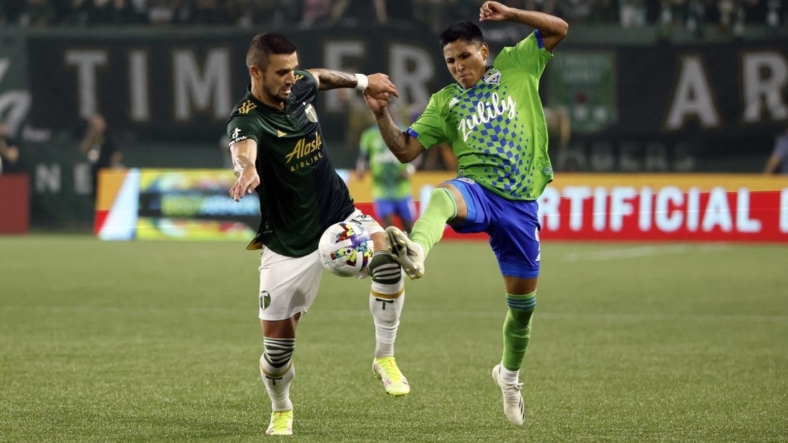 Aug 26, 2022; Portland, Oregon, USA; Portland Timbers defender Dario Zuparic (13, left) battles for the ball with Seattle Sounders forward Raul Ruidiaz (9) during the first half at Providence Park. Mandatory Credit: Soobum Im-USA TODAY Sports
