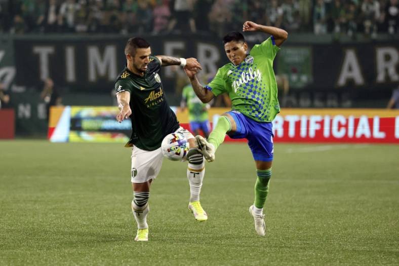 Aug 26, 2022; Portland, Oregon, USA; Portland Timbers defender Dario Zuparic (13, left) battles for the ball with Seattle Sounders forward Raul Ruidiaz (9) during the first half at Providence Park. Mandatory Credit: Soobum Im-USA TODAY Sports