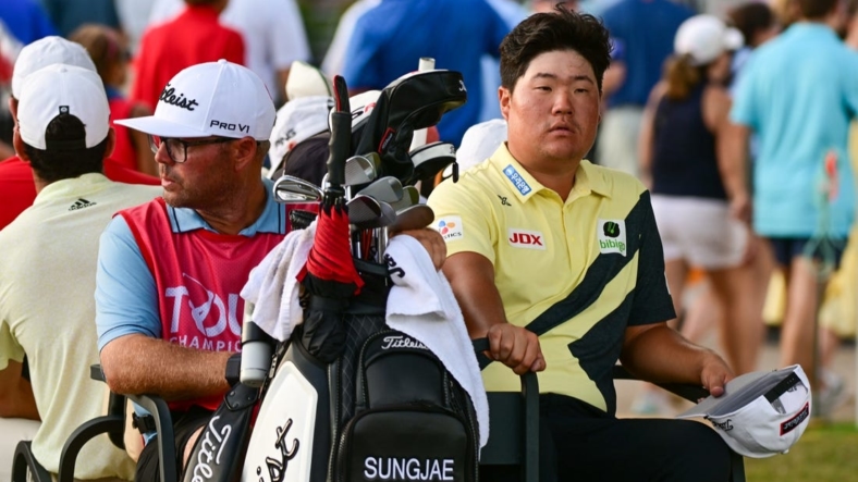 Aug 27, 2022; Atlanta, Georgia, USA; Sungjae Im and his caddie William Spencer ride back to the club house in a golf cart during a weather delay during the third round of the TOUR Championship golf tournament. Mandatory Credit: Adam Hagy-USA TODAY Sports