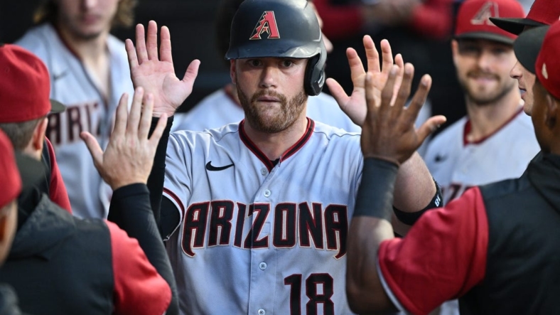 Aug 27, 2022; Chicago, Illinois, USA;  Arizona Diamondbacks catcher Carson Kelly (18) celebrates in the dugout after scoring on a pass ball in the second inning against the Chicago White Sox at Guaranteed Rate Field. Mandatory Credit: Jamie Sabau-USA TODAY Sports