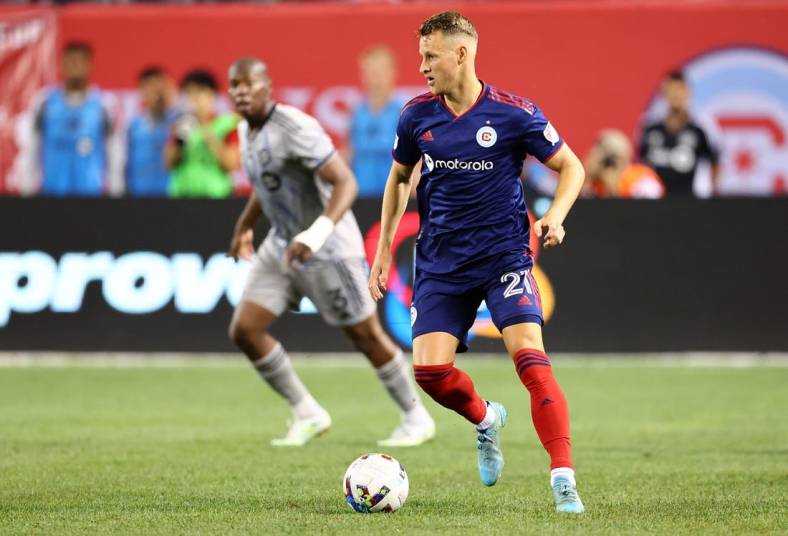 Aug 27, 2022; Chicago, Illinois, USA; Chicago Fire midfielder Fabian Herbers (21) kicks the ball past CF Montreal defender Kamal Miller (3) during the second half at Soldier Field. Mandatory Credit: Mike Dinovo-USA TODAY Sports