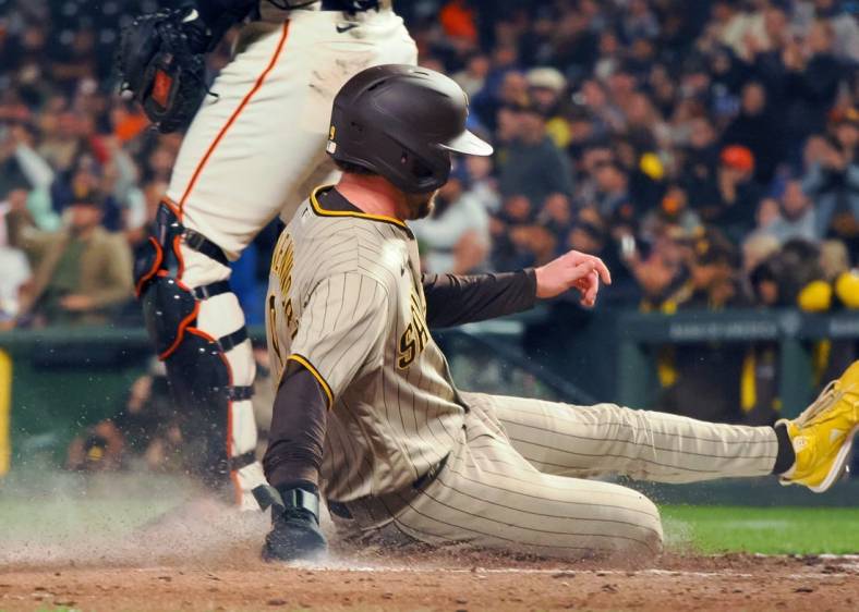 Aug 29, 2022; San Francisco, California, USA; San Diego Padres second baseman Jake Cronenworth (9) slides safely home past San Francisco Giants catcher Joey Bart (21) during the fourth inning at Oracle Park. Mandatory Credit: Kelley L Cox-USA TODAY Sports