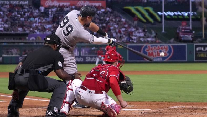 Aug 30, 2022; Anaheim, California, USA; New York Yankees center fielder Aaron Judge (99) bats in the third inning as Los Angeles Angels catcher Max Stassi (33) and home plate umpire Alan Porter watch at Angel Stadium. Mandatory Credit: Kirby Lee-USA TODAY Sports