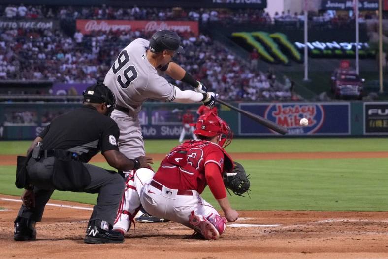Aug 30, 2022; Anaheim, California, USA; New York Yankees center fielder Aaron Judge (99) bats in the third inning as Los Angeles Angels catcher Max Stassi (33) and home plate umpire Alan Porter watch at Angel Stadium. Mandatory Credit: Kirby Lee-USA TODAY Sports