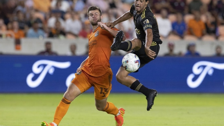Aug 31, 2022; Houston, Texas, USA; Los Angeles FC forward Carlos Vela (10) traps the ball in mid air against Houston Dynamo FC defender Ethan Bartlow (13) in the first half at PNC Stadium. Mandatory Credit: Thomas Shea-USA TODAY Sports