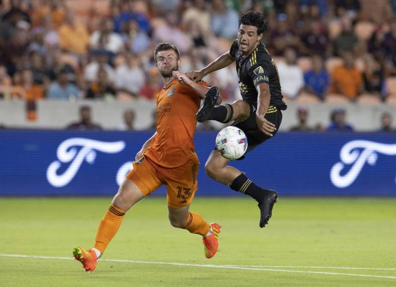 Aug 31, 2022; Houston, Texas, USA; Los Angeles FC forward Carlos Vela (10) traps the ball in mid air against Houston Dynamo FC defender Ethan Bartlow (13) in the first half at PNC Stadium. Mandatory Credit: Thomas Shea-USA TODAY Sports