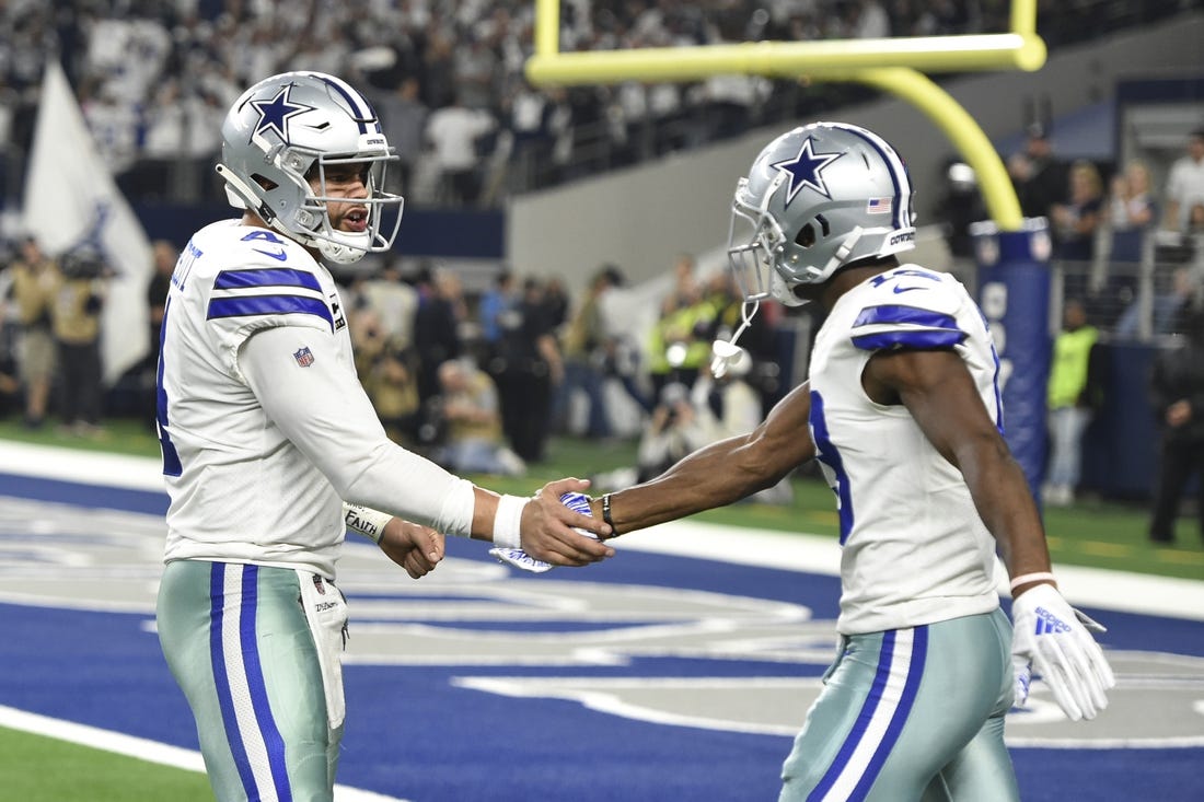 Jan 5, 2019; Arlington, TX, USA; Dallas Cowboys quarterback Dak Prescott (4) reacts after throwing a 11 yard touchdown pass to wide receiver Michael Gallup (13) against the Seattle Seahawks in the second quarter in a NFC Wild Card playoff football game at AT&T Stadium. Mandatory Credit: Shane Roper-USA TODAY Sports