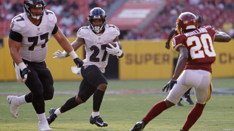 Aug 28, 2021; Landover, Maryland, USA; Baltimore Ravens running back J.K. Dobbins (27) carries the ball as Washington Football Team cornerback Kendall Fuller (29) defends in the first quarter at FedExField. Mandatory Credit: Geoff Burke-USA TODAY Sports
