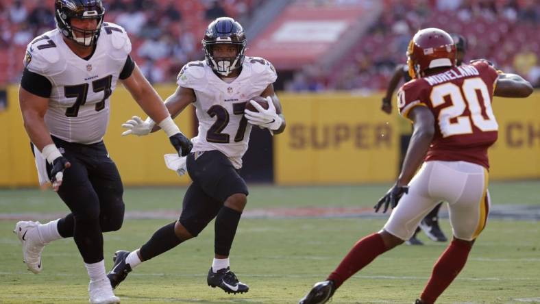 Aug 28, 2021; Landover, Maryland, USA; Baltimore Ravens running back J.K. Dobbins (27) carries the ball as Washington Football Team cornerback Kendall Fuller (29) defends in the first quarter at FedExField. Mandatory Credit: Geoff Burke-USA TODAY Sports