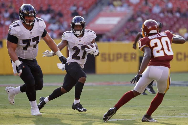 Aug 28, 2021; Landover, Maryland, USA; Baltimore Ravens running back J.K. Dobbins (27) carries the ball as Washington Football Team cornerback Kendall Fuller (29) defends in the first quarter at FedExField. Mandatory Credit: Geoff Burke-USA TODAY Sports