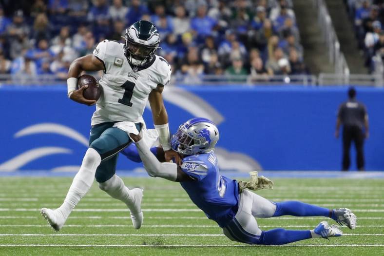 Oct 31, 2021; Detroit, Michigan, USA; Philadelphia Eagles quarterback Jalen Hurts (1) runs the ball against Detroit Lions free safety Tracy Walker III (21) during the third quarter at Ford Field. Mandatory Credit: Raj Mehta-USA TODAY Sports