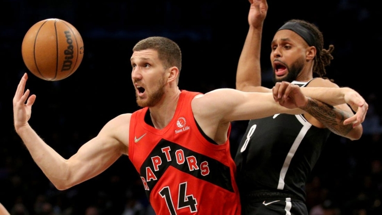 Dec 14, 2021; Brooklyn, New York, USA; Toronto Raptors guard Svi Mykhailiuk (14) loses the ball as he drives to the basket against Brooklyn Nets guard Patty Mills (8) during the first quarter at Barclays Center. Mandatory Credit: Brad Penner-USA TODAY Sports