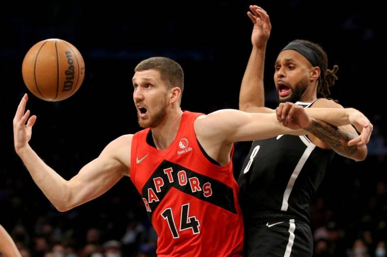 Dec 14, 2021; Brooklyn, New York, USA; Toronto Raptors guard Svi Mykhailiuk (14) loses the ball as he drives to the basket against Brooklyn Nets guard Patty Mills (8) during the first quarter at Barclays Center. Mandatory Credit: Brad Penner-USA TODAY Sports