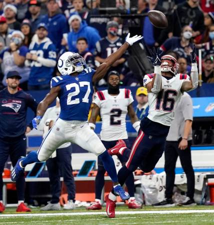 A pass intended for New England Patriots wide receiver Jakobi Meyers (16) goes incomplete as Indianapolis Colts cornerback Xavier Rhodes (27) reaches for the ball Saturday, Dec. 18, 2021, during a game against the New England Patriots at Lucas Oil Stadium in Indianapolis.