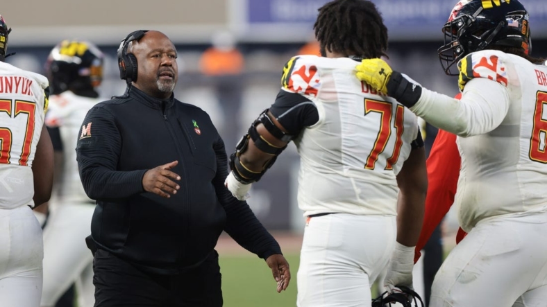 Dec 29, 2021; New York, NY, USA; Maryland Terrapins head coach Mike Locksley (left) talks with offensive lineman Jaelyn Duncan (71) during the second half of the 2021 Pinstripe Bowl against the Virginia Tech Hokies at Yankee Stadium. Mandatory Credit: Vincent Carchietta-USA TODAY Sports