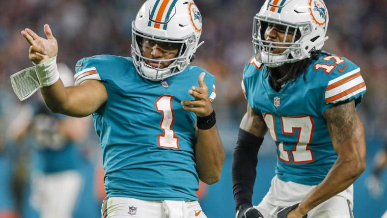 Jan 9, 2022; Miami Gardens, Florida, USA; Miami Dolphins quarterback Tua Tagovailoa (1) reacts with wide receiver Jaylen Waddle (17) after running with the football for a first down against the New England Patriots during the fourth quarter at Hard Rock Stadium. Mandatory Credit: Sam Navarro-USA TODAY Sports