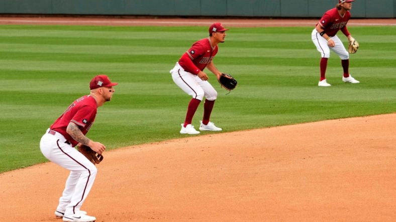 Arizona Diamondbacks infielders Drew Ellis, Josh Rojas, and Jake Hager shift to the right side of second base against the Los Angeles Dodgers in the fourth inning during a spring training game at Salt River Fields.Baseball Los Angeles Dodgers At Arizona Diamondbacks
