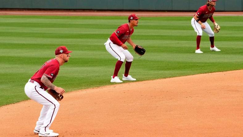 Arizona Diamondbacks infielders Drew Ellis, Josh Rojas, and Jake Hager shift to the right side of second base against the Los Angeles Dodgers in the fourth inning during a spring training game at Salt River Fields.

Baseball Los Angeles Dodgers At Arizona Diamondbacks