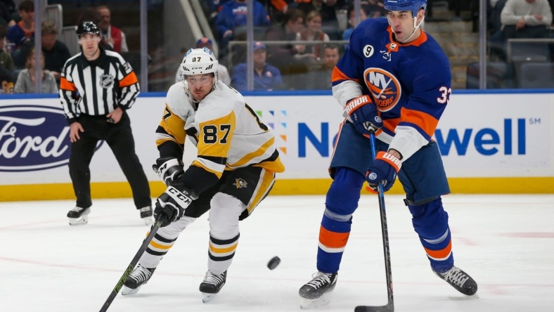 Apr 12, 2022; Elmont, New York, USA; Pittsburgh Penguins center Sidney Crosby (87) and New York Islanders defenseman Zdeno Chara (33) battle for the puck during the first period at UBS Arena. Mandatory Credit: Tom Horak-USA TODAY Sports