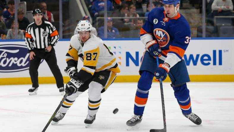 Apr 12, 2022; Elmont, New York, USA; Pittsburgh Penguins center Sidney Crosby (87) and New York Islanders defenseman Zdeno Chara (33) battle for the puck during the first period at UBS Arena. Mandatory Credit: Tom Horak-USA TODAY Sports