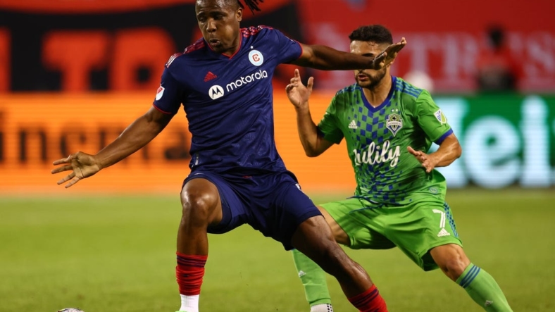 Jul 16, 2022; Chicago, Illinois, USA; Chicago Fire forward Chinonso Offor (9) kicks the ball around Seattle Sounders midfielder Cristian Roldan (7) during the second half at Soldier Field. Mandatory Credit: Mike Dinovo-USA TODAY Sports