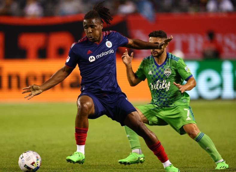 Jul 16, 2022; Chicago, Illinois, USA; Chicago Fire forward Chinonso Offor (9) kicks the ball around Seattle Sounders midfielder Cristian Roldan (7) during the second half at Soldier Field. Mandatory Credit: Mike Dinovo-USA TODAY Sports