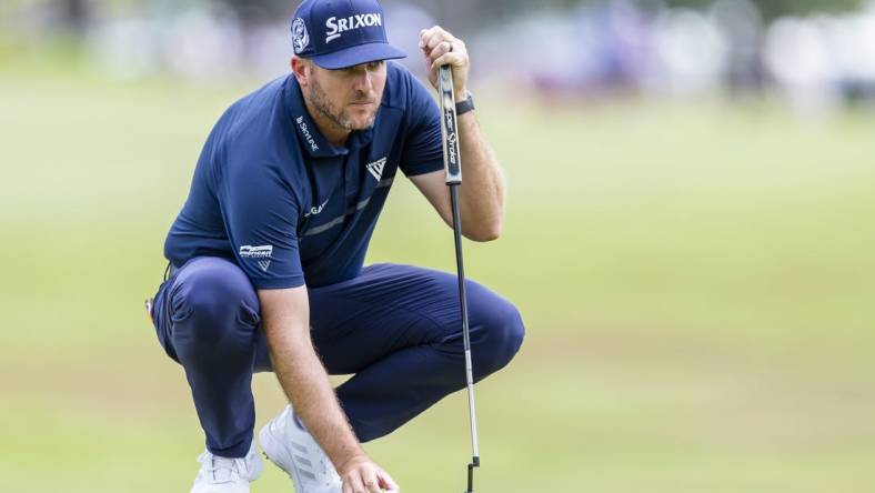 Jul 31, 2022; Detroit, Michigan, USA; Taylor Pendrith places his ball on the green on the par 4 first hole during the final round of the Rocket Mortgage Classic golf tournament. Mandatory Credit: Raj Mehta-USA TODAY Sports