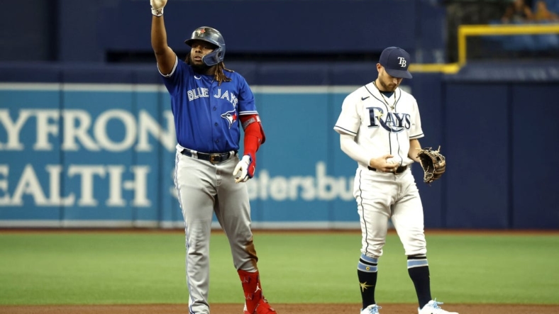 Aug 2, 2022; St. Petersburg, Florida, USA; Toronto Blue Jays first baseman Vladimir Guerrero Jr. (27) celebrates after hitting a double as Tampa Bay Rays second baseman Brandon Lowe (8) looks down during the first inning at Tropicana Field. Mandatory Credit: Kim Klement-USA TODAY Sports