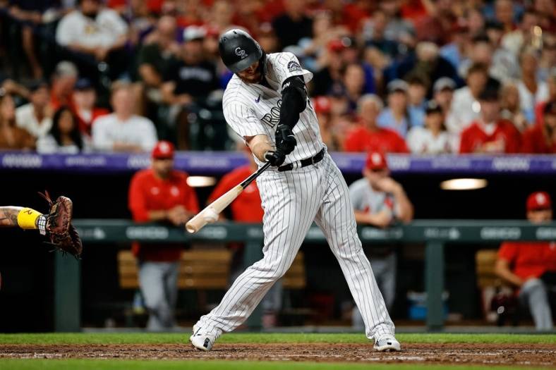Aug 10, 2022; Denver, Colorado, USA; Colorado Rockies first baseman C.J. Cron (25) hits an RBI triple in the fifth inning against the St. Louis Cardinals at Coors Field. Mandatory Credit: Isaiah J. Downing-USA TODAY Sports