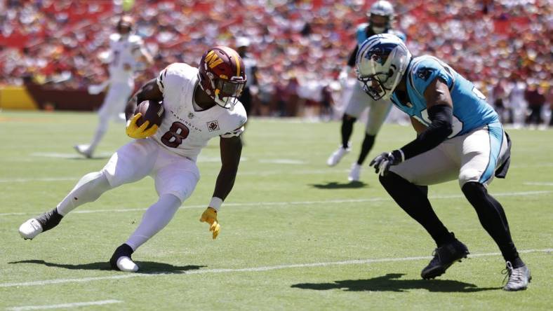 Aug 13, 2022; Landover, Maryland, USA; Washington Commanders running back Brian Robinson (8) runs with the ball as Carolina Panthers cornerback Chris Westry (39) defends during the second quarter at FedExField. Mandatory Credit: Geoff Burke-USA TODAY Sports