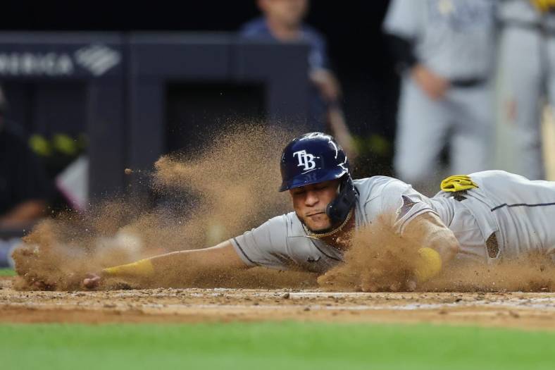 Aug 17, 2022; Bronx, New York, USA; Tampa Bay Rays center fielder Jose Siri (22) slides into home to score a run against the New York Yankees on a double by Rays third baseman Yandy Diaz (not pictured) during the third inning at Yankee Stadium. Mandatory Credit: Brad Penner-USA TODAY Sports
