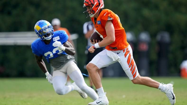 Cincinnati Bengals quarterback Joe Burrow (9) runs out of the pocket as Los Angeles Rams running back Kyren Williams (23) defends during a joint practice, Wednesday, Aug. 24, 2022, at the Paycor Stadium practice fields in Cincinnati.

Los Angeles Rams At Cincinnati Bengals Joint Practice Aug 24 0064