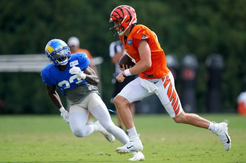 Cincinnati Bengals quarterback Joe Burrow (9) runs out of the pocket as Los Angeles Rams running back Kyren Williams (23) defends during a joint practice, Wednesday, Aug. 24, 2022, at the Paycor Stadium practice fields in Cincinnati.

Los Angeles Rams At Cincinnati Bengals Joint Practice Aug 24 0064
