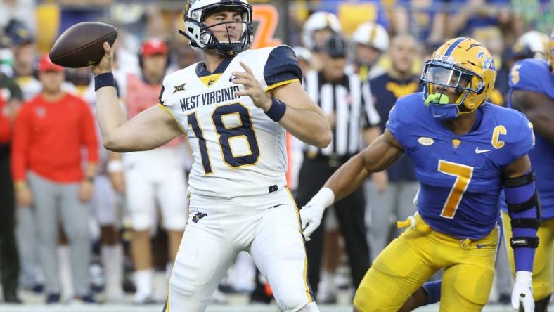 Sep 1, 2022; Pittsburgh, Pennsylvania, USA; West Virginia Mountaineers quarterback JT Daniels (18) passes against pressure from Pittsburgh Panthers linebacker SirVocea Dennis (7) during the first quarter at Acrisure Stadium. Mandatory Credit: Charles LeClaire-USA TODAY Sports