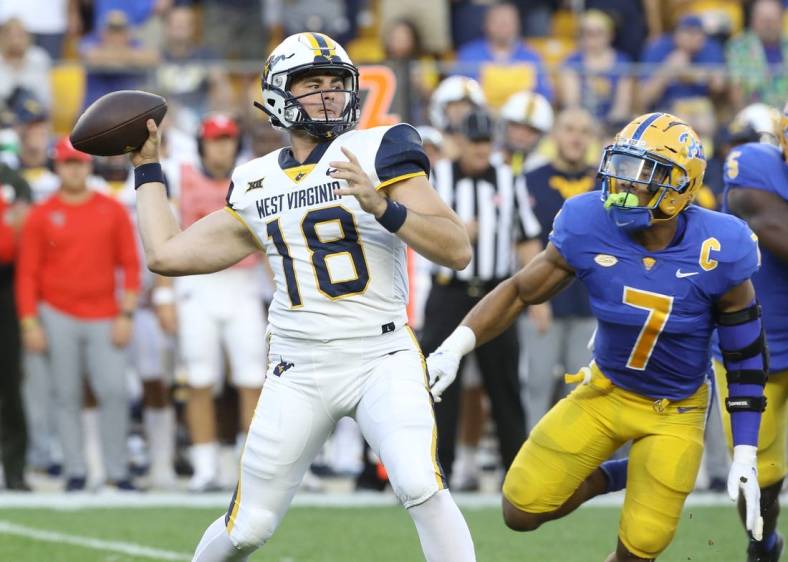 Sep 1, 2022; Pittsburgh, Pennsylvania, USA; West Virginia Mountaineers quarterback JT Daniels (18) passes against pressure from Pittsburgh Panthers linebacker SirVocea Dennis (7) during the first quarter at Acrisure Stadium. Mandatory Credit: Charles LeClaire-USA TODAY Sports