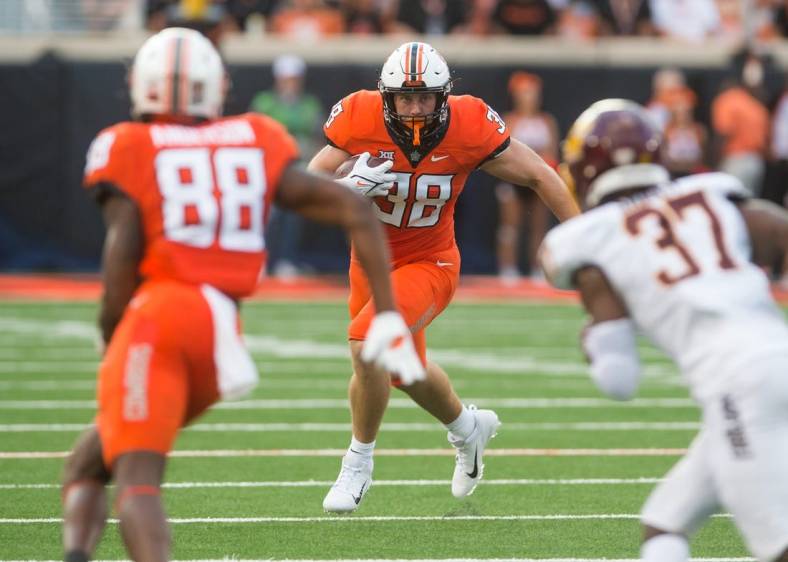 Sep 1, 2022; Stillwater, Oklahoma, USA; Oklahoma State Cowboys fullback Jake Schultz (38) turns to run after a catch during the second quarter against the Central Michigan Chippewas at Boone Pickens Stadium. Mandatory Credit: Brett Rojo-USA TODAY Sports