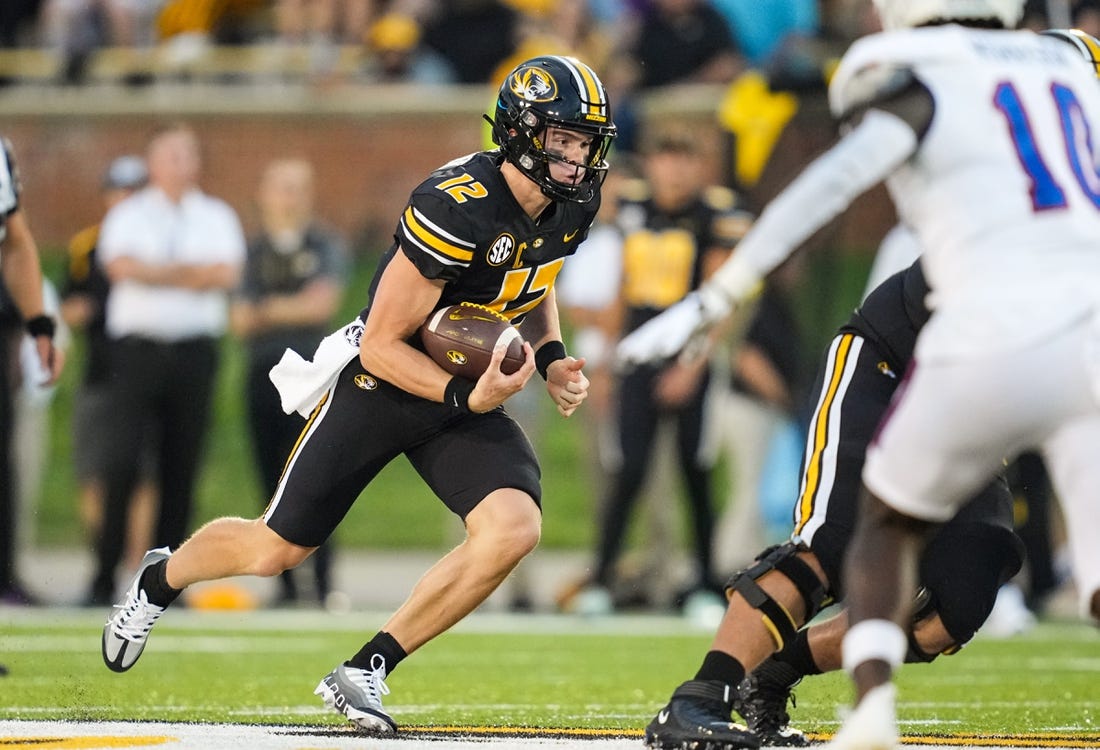 Sep 1, 2022; Columbia, Missouri, USA; Missouri Tigers quarterback Brady Cook (12) runs the ball against the Louisiana Tech Bulldogs during the first half at Faurot Field at Memorial Stadium. Mandatory Credit: Jay Biggerstaff-USA TODAY Sports