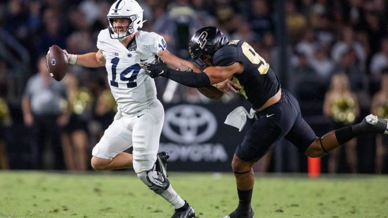 Sep 1, 2022; West Lafayette, Indiana, USA; Penn State Nittany Lions quarterback Sean Clifford (14) runs to pass the ball while Purdue Boilermakers defensive tackle Lawrence Johnson (90) defends  in the second quarter at Ross-Ade Stadium. Mandatory Credit: Trevor Ruszkowski-USA TODAY Sports