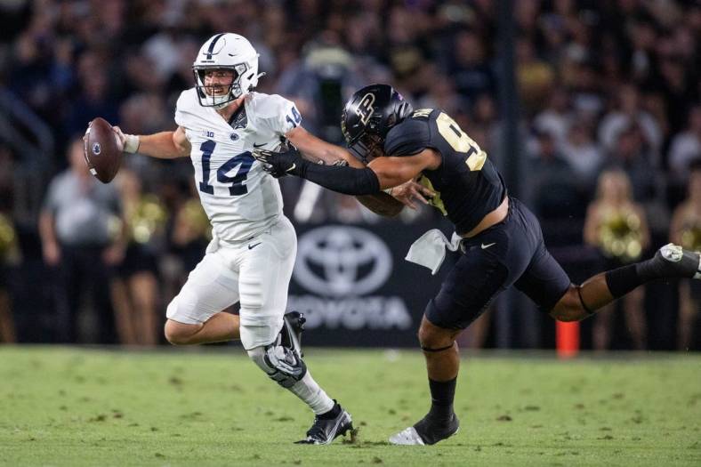 Sep 1, 2022; West Lafayette, Indiana, USA; Penn State Nittany Lions quarterback Sean Clifford (14) runs to pass the ball while Purdue Boilermakers defensive tackle Lawrence Johnson (90) defends  in the second quarter at Ross-Ade Stadium. Mandatory Credit: Trevor Ruszkowski-USA TODAY Sports