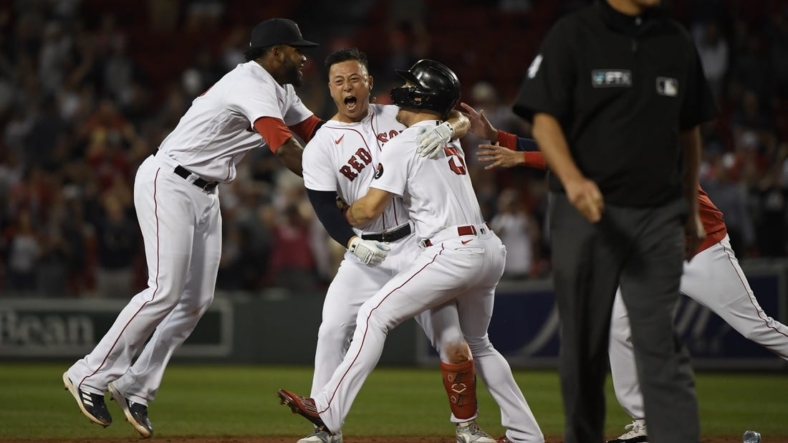 Sep 1, 2022; Boston, Massachusetts, USA; Boston Red Sox center fielder Rob Refsnyder (30) is mobbed by center fielder Enrique Hernandez (5) and first baseman Franchy Cordero (16) after hitting a walk off single during the ninth inning against the Texas Rangers at Fenway Park. Mandatory Credit: Bob DeChiara-USA TODAY Sports