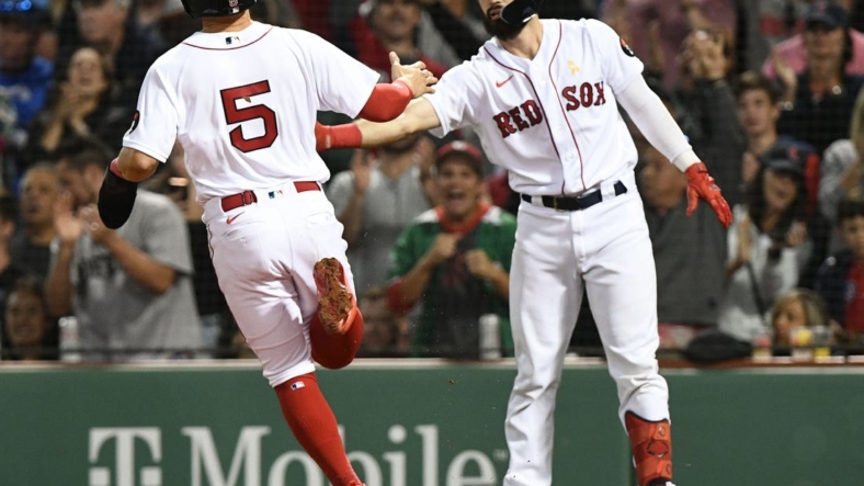 Sep 2, 2022; Boston, Massachusetts, USA; Boston Red Sox center fielder Enrique Hernandez (5) celebrates with catcher Connor Wong (74) after scoring a run against the Texas Rangers during the fourth inning at Fenway Park. Mandatory Credit: Brian Fluharty-USA TODAY Sports