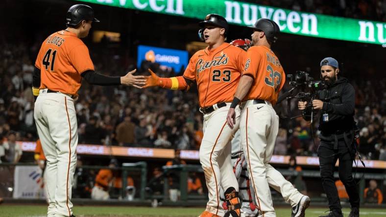 Sep 2, 2022; San Francisco, California, USA; San Francisco Giants left fielder Joc Pederson (23) celebrates with catcher Andrew Knapp (33) and designated hitter Wilmer Flores (41) after hitting a three-run home run against the Philadelphia Phillies during the second inning at Oracle Park. Mandatory Credit: John Hefti-USA TODAY Sports