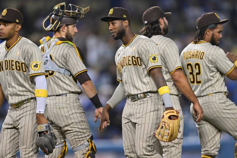 Sep 2, 2022; Los Angeles, California, USA;  San Diego Padres catcher Austin Nola (26) shakes hands with San left fielder Jurickson Profar (10) after the final out of the ninth inning defeating the Los Angeles Dodgers at Dodger Stadium. Mandatory Credit: Jayne Kamin-Oncea-USA TODAY Sports