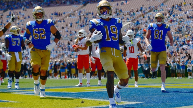 Sep 3, 2022; Pasadena, California, USA; UCLA Bruins wide receiver Kazmeir Allen (19) scores a touchdown against the Bowling Green Falcons during the first half at Rose Bowl. Mandatory Credit: Gary A. Vasquez-USA TODAY Sports