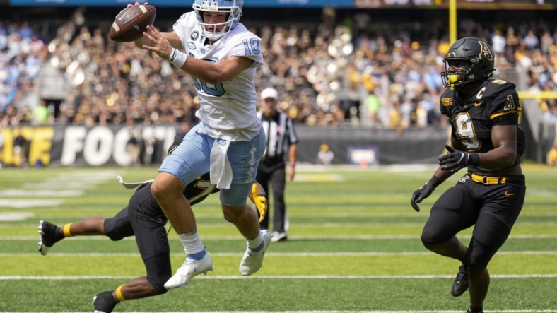 Sep 3, 2022; Boone, North Carolina, USA; North Carolina Tar Heels quarterback Drake Maye (10) dives into the end zone for the two point conversion attempt pursued by Appalachian State Mountaineers linebacker Nick Hampton (9) during the second half at Kidd Brewer Stadium. Mandatory Credit: Jim Dedmon-USA TODAY Sports