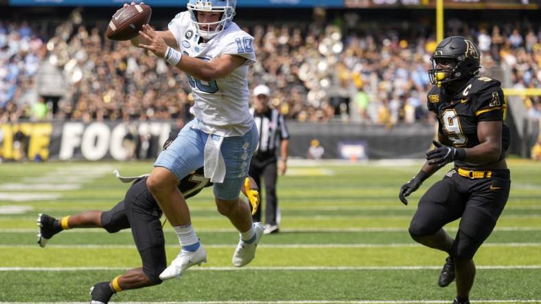 Sep 3, 2022; Boone, North Carolina, USA; North Carolina Tar Heels quarterback Drake Maye (10) dives into the end zone for the two point conversion attempt pursued by Appalachian State Mountaineers linebacker Nick Hampton (9) during the second half at Kidd Brewer Stadium. Mandatory Credit: Jim Dedmon-USA TODAY Sports