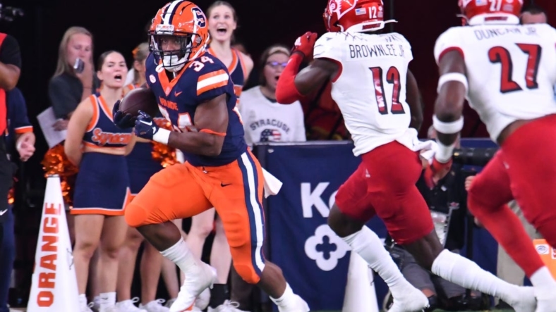 Sep 3, 2022; Syracuse, New York, USA; Syracuse Orange running back Sean Tucker (34) runs against Louisville Cardinals cornerback Jarvis Brownlee (12) in the first quarter at JMA Wireless Dome. Mandatory Credit: Mark Konezny-USA TODAY Sports