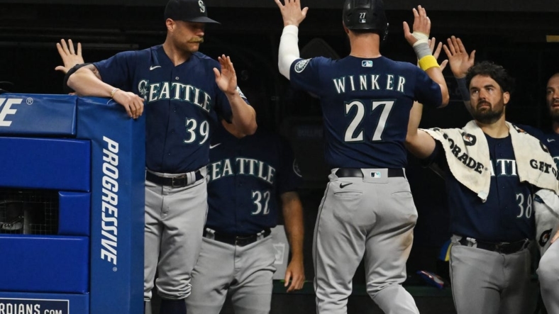 Sep 3, 2022; Cleveland, Ohio, USA; Seattle Mariners left fielder Jesse Winker (27) celebrates with major league field coordinator Carson Vitale (39) and starting pitcher Robbie Ray (38) after scoring during the fifth inning against the Cleveland Guardians at Progressive Field. Mandatory Credit: Ken Blaze-USA TODAY Sports