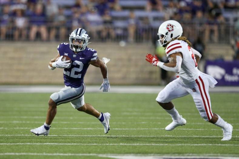 Sep 3, 2022; Manhattan, Kansas, USA; Kansas State Wildcats running back Deuce Vaughn (22) is chased by South Dakota Coyotes linebacker Tre Thomas (21) during the second quarter at Bill Snyder Family Football Stadium. Mandatory Credit: Scott Sewell-USA TODAY Sports